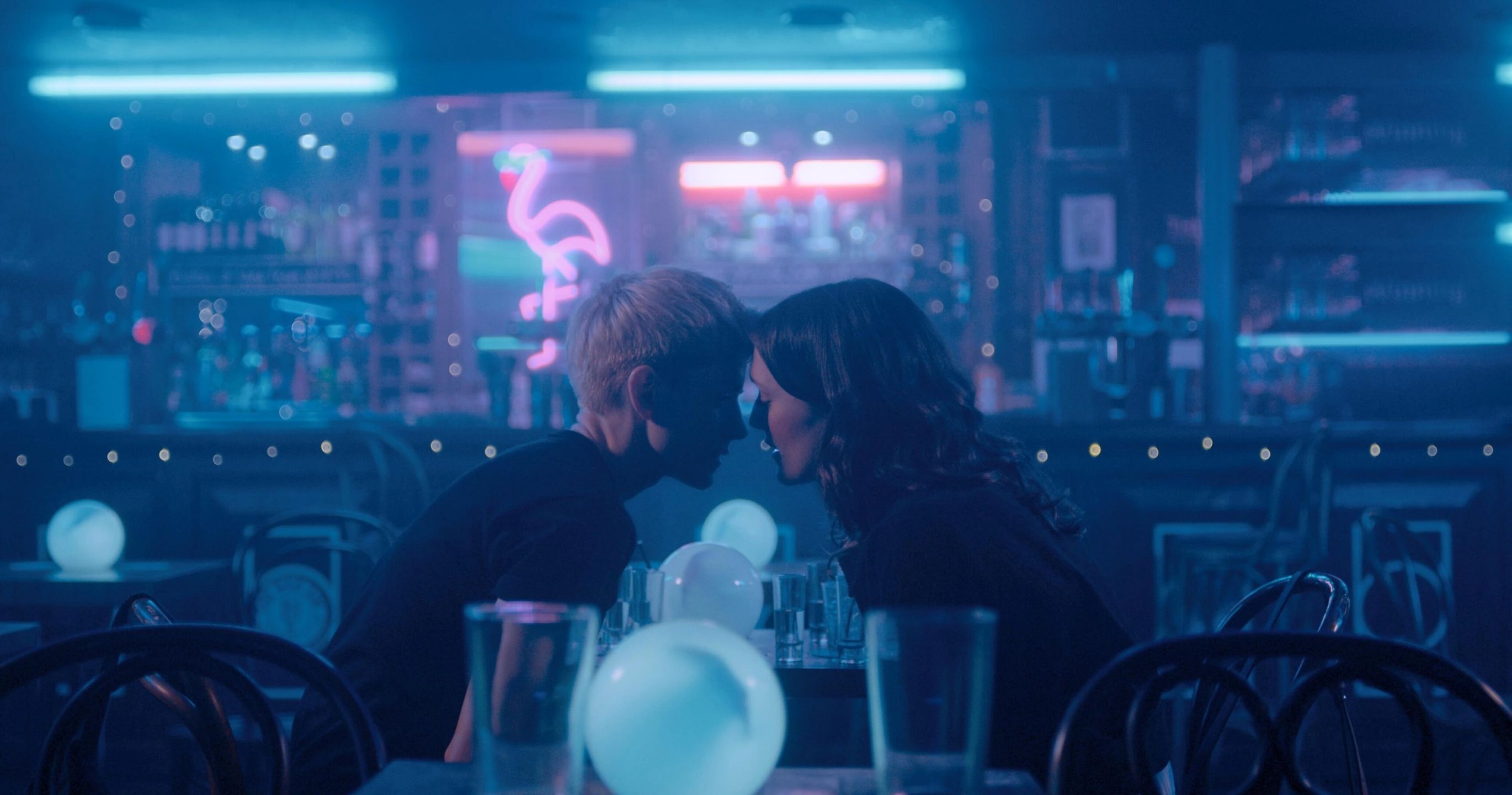 Two women about to kiss in a deserted bar