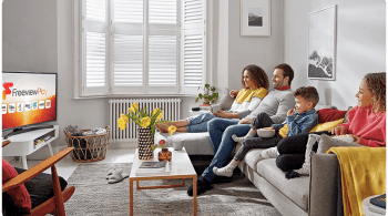 Family sitting on a sofa watching TV