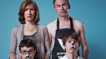 Looks like a formal family portrait, however dad is only wearing an apron and both sons have spoons on their noses