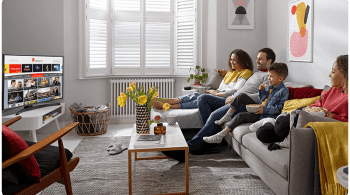 Family sitting on a sofa watching TV