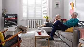 An older couple scrolling through the new Accessible TV Guide on their Freeview Play TV